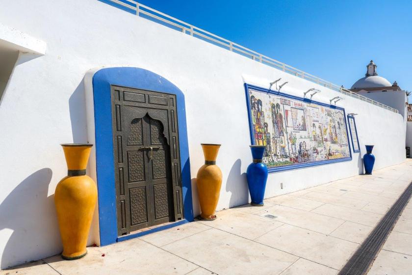 jarras em tonalidade azul e uma porta de estilo árabe no exterior do jardim Frutuoso da Silva