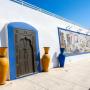 jarras em tonalidade azul e uma porta de estilo árabe no exterior do jardim Frutuoso da Silva